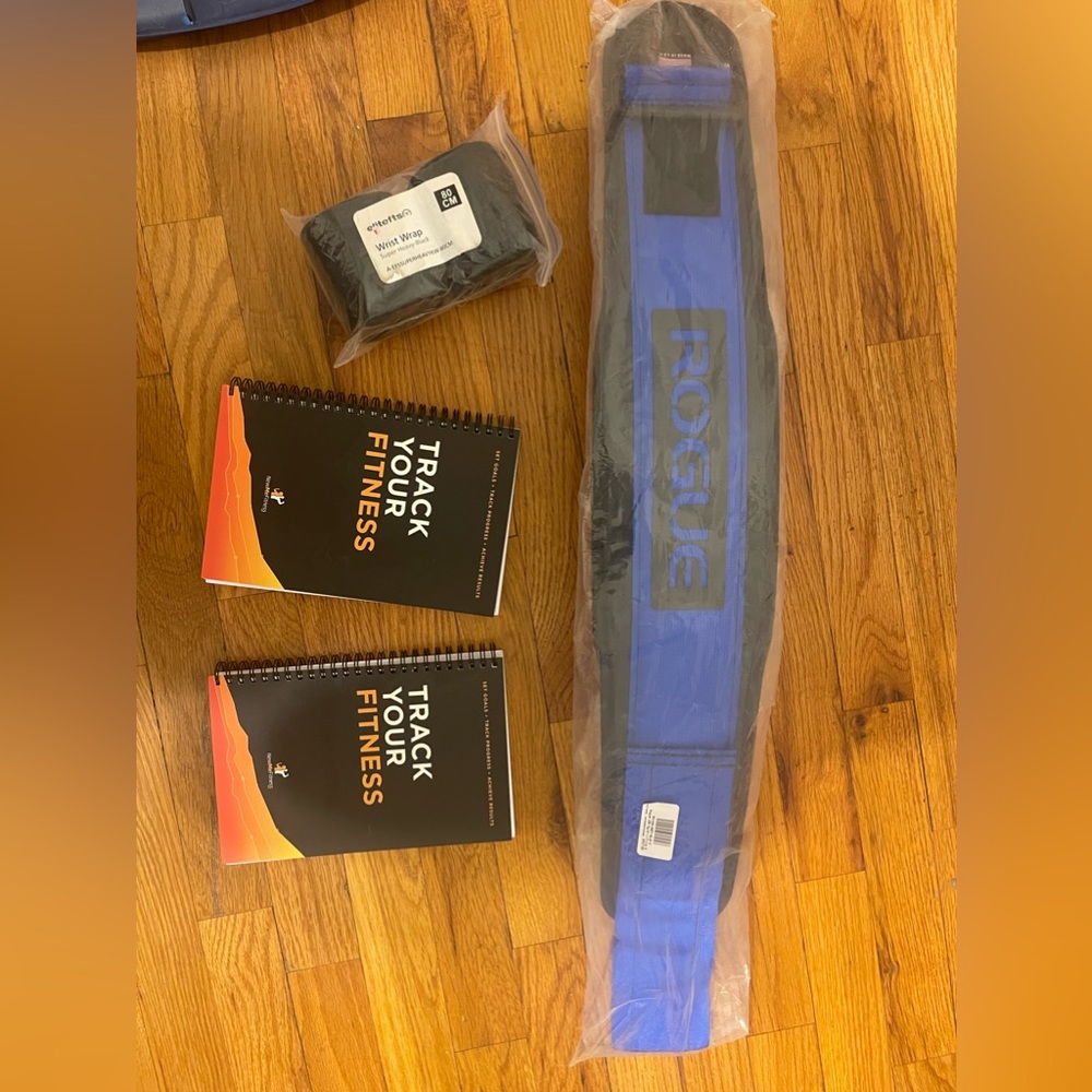 Size Small lift belt, a pair of lifting straps, and 2 workout progress books.